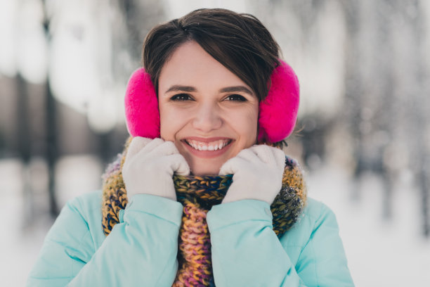 开朗积极年轻女士的照片微笑好心情戴耳套雪天气冬天在公园户外图片下载