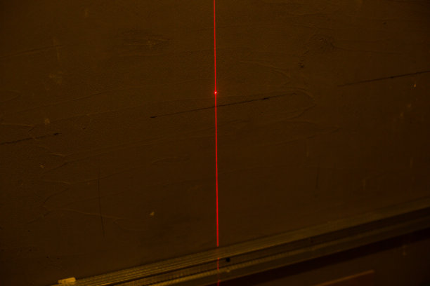 红色激光水平，施工，维修工作在房间。装修卷尺与红色激光水平在墙上。维护。图片下载