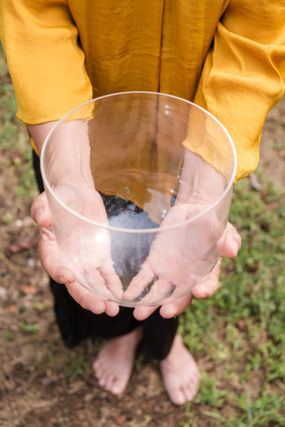 女人的肖像手持石英水晶唱歌碗与双手。垂直的照片。图片下载