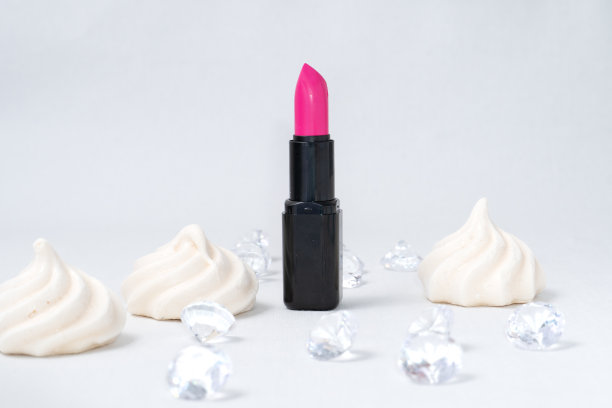 美丽的照片唇膏和法国迷你蛋白饼干的特写在浅白色背景与假钻石图片下载
