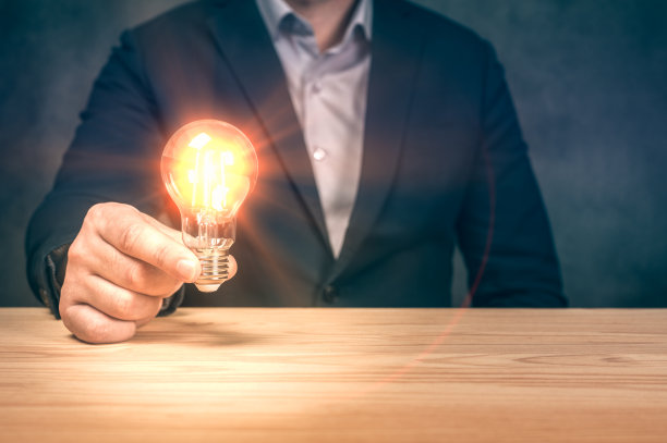 商人手握照明灯泡，理念，创新和灵感的概念。创新未来与科技。发光灯泡的创造力。灵感的想法图片下载