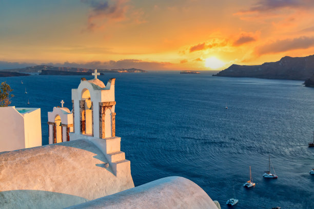 标志性的希腊的照片。希腊爱琴海圣托里尼岛，美丽的日落与著名的东正教教堂。图片下载