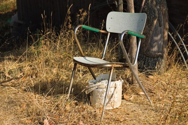 废弃在田里的生锈椅子和白色塑料桶(翁布里亚，意大利，欧洲)图片下载