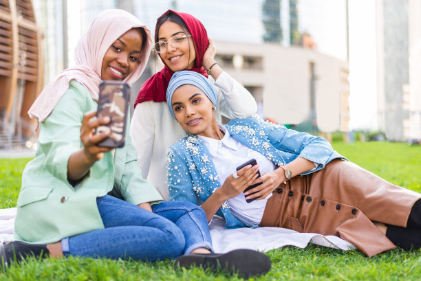 美丽的穆斯林女孩戴着头巾在户外聊天图片下载