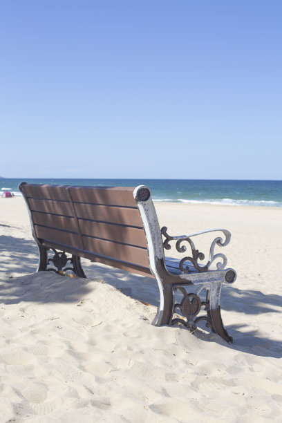 空荡荡的沙滩旁的木凳。图片下载