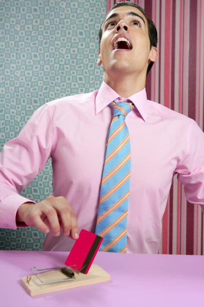 年轻的商人手里拿着信用卡夹在老鼠夹里图片下载