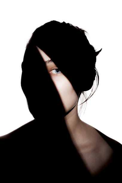 时尚工作室的可爱女孩的肖像。一个美丽的年轻女子的剪影，脸上有坚硬的阴影。对白色背景图片下载