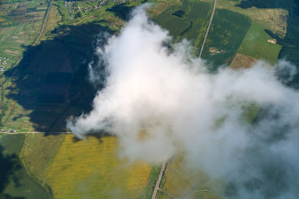 高空从飞机窗口鸟瞰被白色蓬松积云覆盖的地球。图片下载
