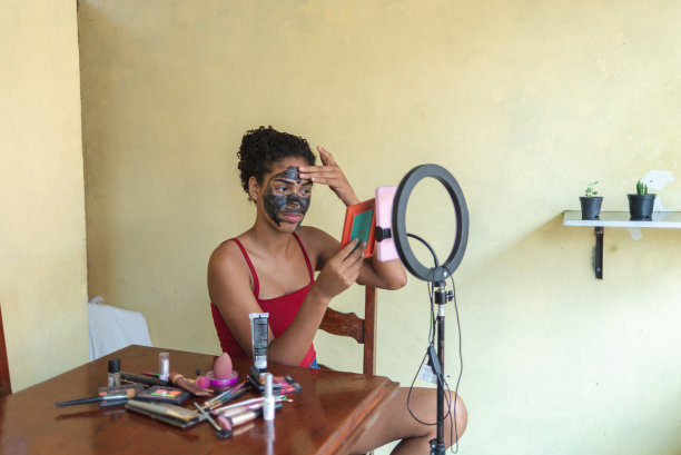 一名黑人女性在直播视频中讲解如何剥去面膜进行面部皮肤护理图片下载