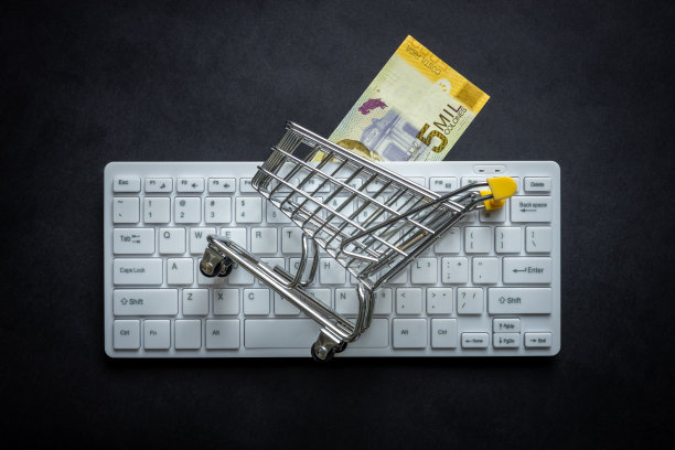 哥斯达黎加币，白色电脑键盘，迷你购物车，黑色背景，网上购物概念，低价图片下载