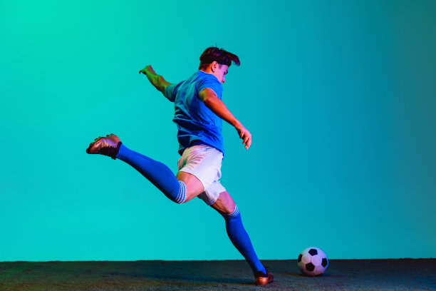 全身像的年轻白人足球运动员积极训练孤立的蓝色背景图片下载