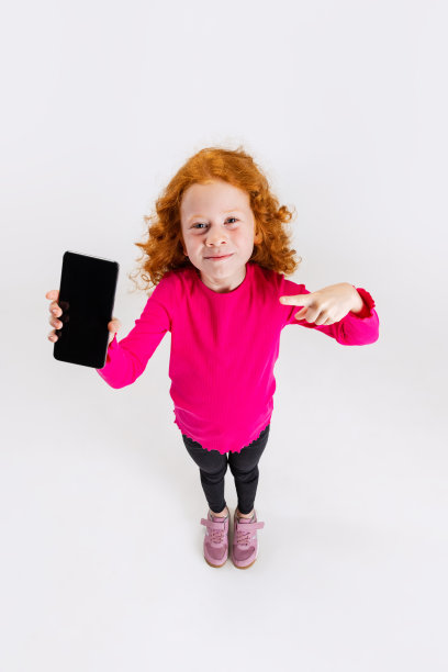 小白人女孩的俯视图肖像，孩子在灰色的工作室背景上孤立。图片下载