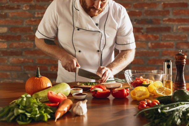 特写男厨师的手，厨师准备新鲜蔬菜沙拉在他的咖啡馆，餐厅厨房。正确健康饮食的观念图片下载