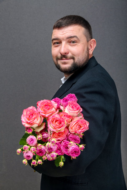 一个穿着夹克的年轻人的画像，手里拿着一束玫瑰花图片下载