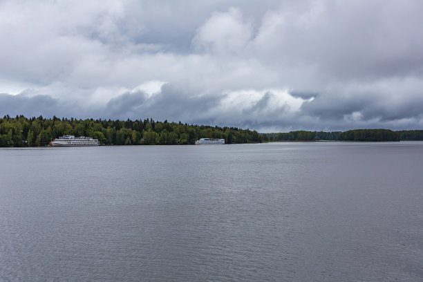 白色游轮停泊在绿色的森林图片下载