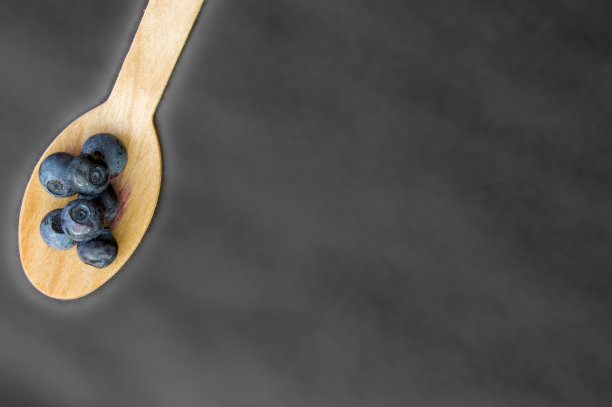 回收的勺子和多汁、新鲜、健康的蓝莓放在餐桌上图片下载