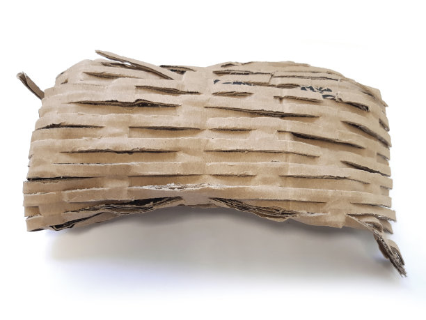 封闭的碎纸填料。用于邮政包裹运输的白色背景衬垫。环保包装材料。纸板制成的碎纸和填充料。图片下载