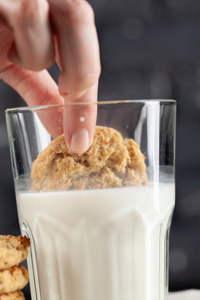 女性手在牛奶中浸泡饼干近距离图片下载