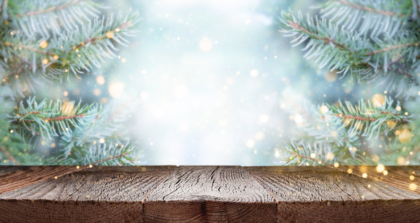空木桌上方的冷杉树枝与雪和散焦的灯。图片下载