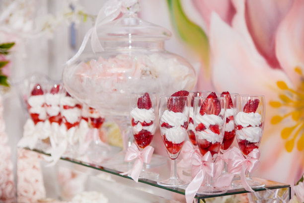自助餐区婚礼糖果吧的美味甜点:玻璃杯里有草莓和鲜奶油图片下载