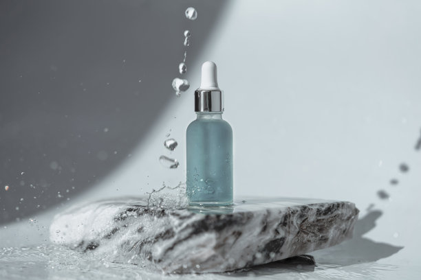 带吸管的化妆瓶立在石头上。图片下载