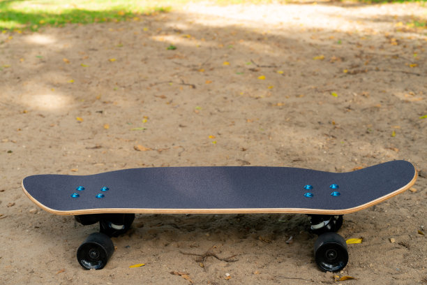 在公园里的沙滩上有一种黑色的冲浪滑板，它有黑色的滑板顶和黑色的轮子。图片下载