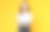 摄影棚拍摄的开朗美丽的亚洲女人在白色t恤和手持笔记本电脑模型的空白屏幕上的黄色背景。图片下载