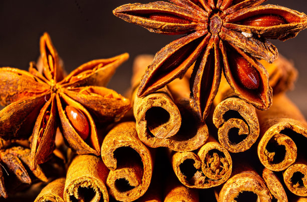 圣诞烘焙香料，肉桂棒和八角星为圣诞蛋糕，饼干或热葡萄酒在黑色背景，微距照片图片下载