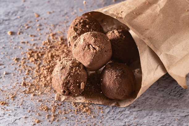 巧克力松露装在纸袋里，撒上可可粉图片下载