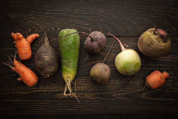 把蔬菜根放在木制背景上图片下载