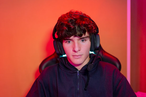年轻人戴着耳机，在霓虹灯照明下图片下载