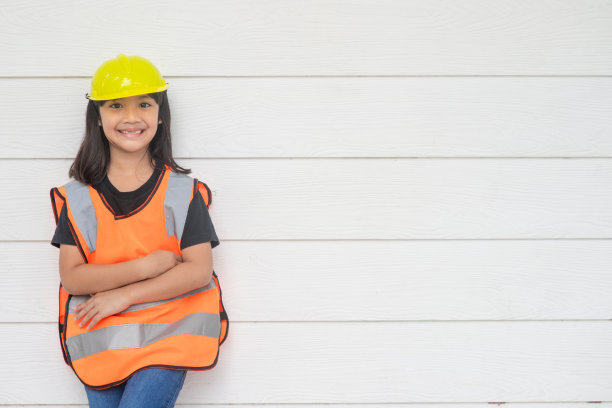 亚洲小女孩穿着反光衬衫，戴着黄色帽子。以学习和提高发展，小建筑师。图片下载