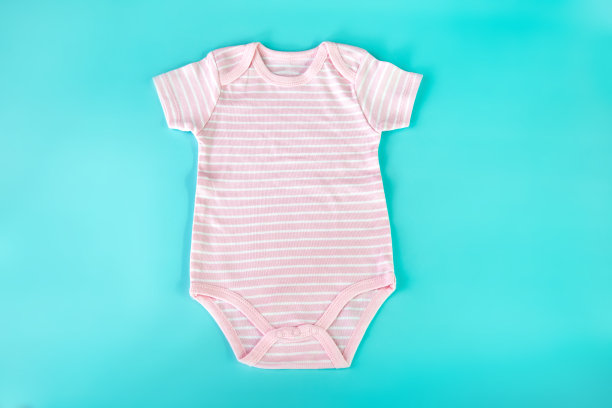 淡粉色婴儿连身衣，浅蓝色背景图片下载