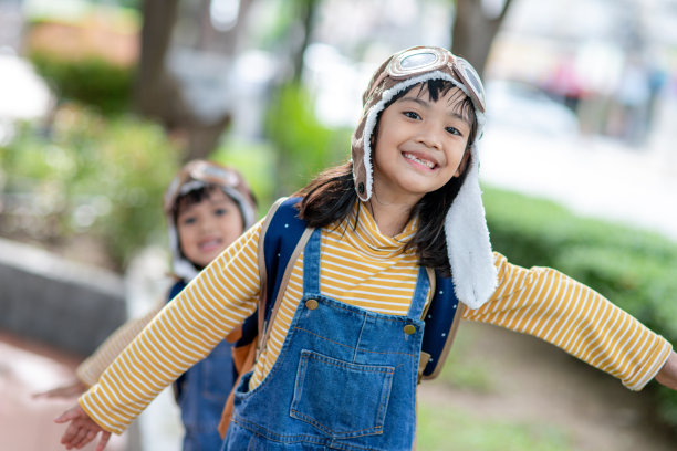 一个可爱的小女孩，戴着飞行员的帽子和眼镜。这孩子梦想成为一名飞行员。图片下载