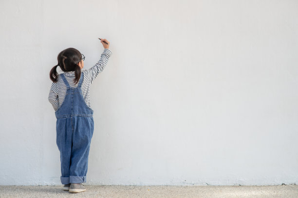 小孩子们在白墙上画画图片下载