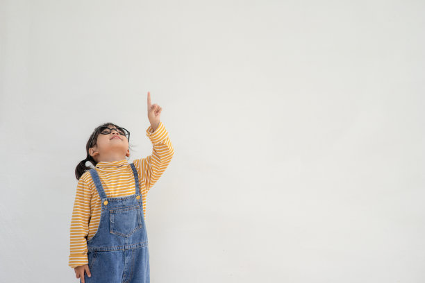 看那里。女学生指着在白色背景上复制空间。图片下载