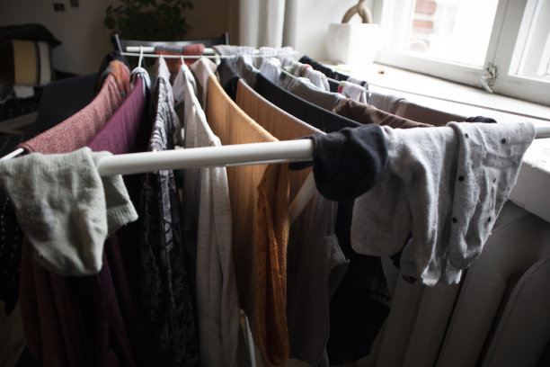 在散热器附近的室内衣架上晾晒多色衣物图片下载
