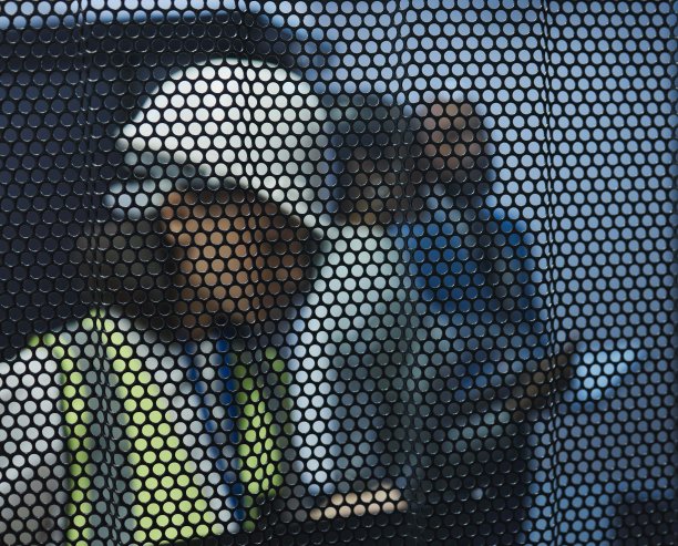 一名年轻女子在工作时躲在屏幕后查看笔记图片下载