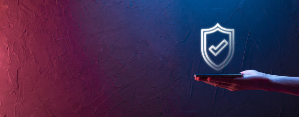 男性手握保护盾与检查标志图标在蓝色背景。保护网络安全，保护计算机和保护您的数据的概念。图片下载