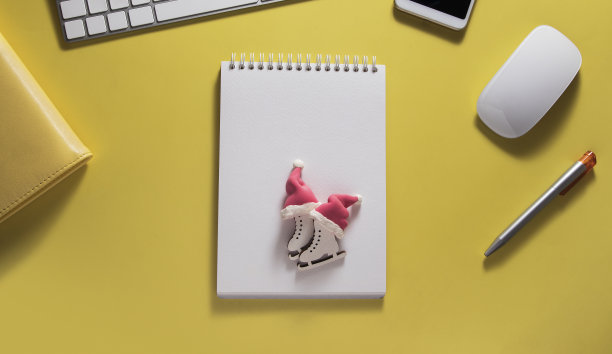 顶视图的桌面与键盘，鼠标和笔记本与溜冰在圣诞老人的帽子:新年概念，计划冬季旅行图片下载