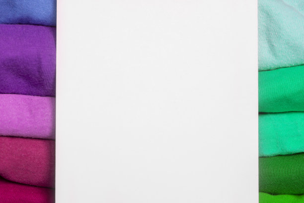 冷色和暖色的多色面料堆叠在一起进行比较。背景与折叠的衣服与空白的信息。不同颜色的t恤图片下载