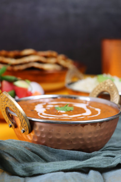 金属卡德海风格的服务碗自制的Dal makhani(黑扁豆和红芸豆)咖喱食谱，白米饭配沙拉，印度烤饼，灰色的棉布，灰色的背景，聚焦前景图片下载