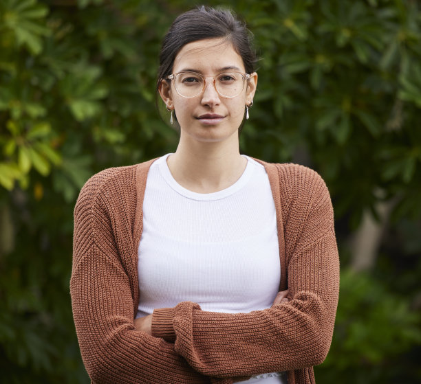 一个年轻女子的肖像，站在户外，双臂交叉图片下载