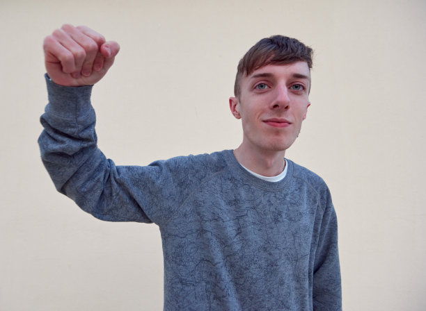 一名来自西班牙的年轻白人男子以拳击姿势站在普通的背景上图片下载