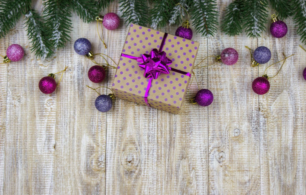 木制背景上装着新年玩具的圣诞盒子。图片下载