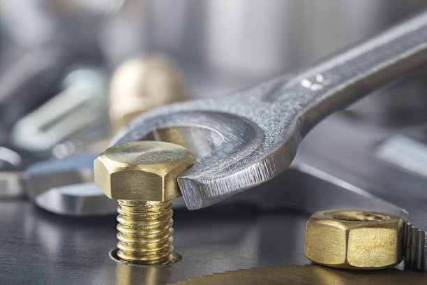 扳手用来拧紧钢坯中的黄铜螺栓。扳手、螺栓、螺钉和螺母。图片下载