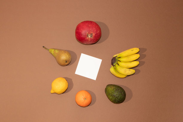 夏季热带布局，新鲜的水果与白色的纸在棕色的背景。最小平。图片下载