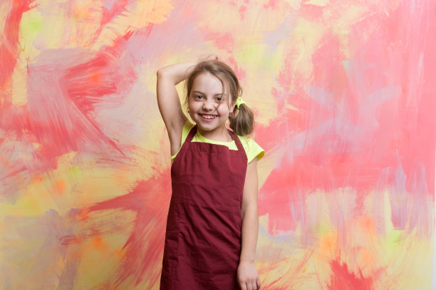 小女孩厨师穿着围裙，脸上挂着快乐的表情图片下载