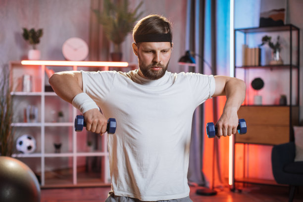 全神贯注的男子用哑铃练习手臂图片下载