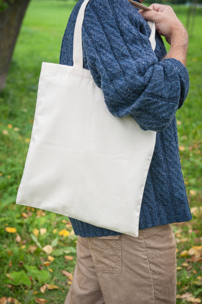 时尚男子手持白色空白帆布手提袋购物图片下载